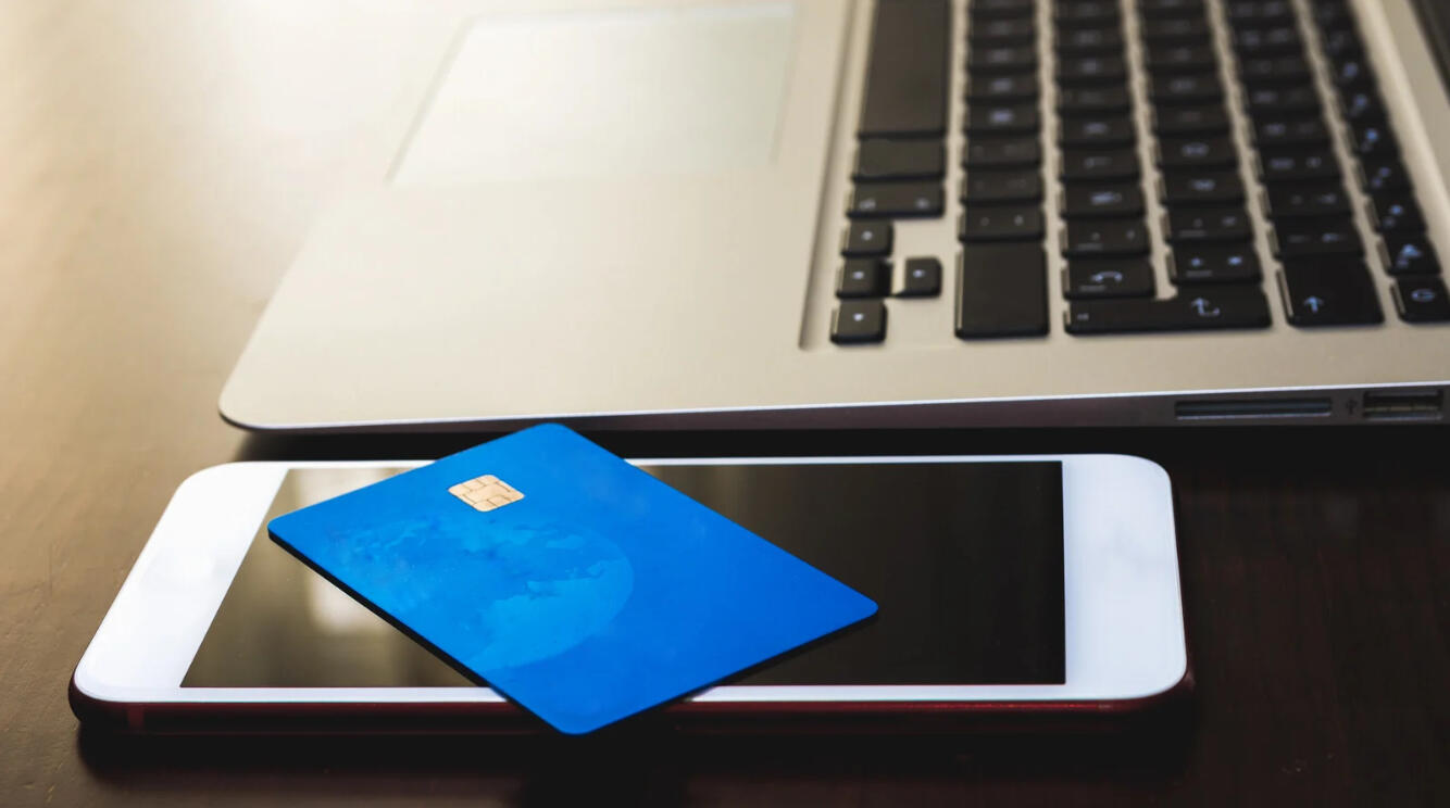 Picture of a debit card, a cell phone, and a laptop computer